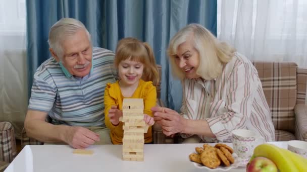 Izgalmas gyermek lány gyerek részt vesz építőkockák társasjáték idősebb nagymama és nagyapa — Stock videók