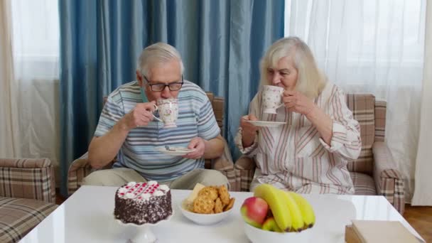 Maduro familia pareja abuelo, abuela relajarse en acogedor sofá disfrutando de la conversación en casa — Vídeo de stock