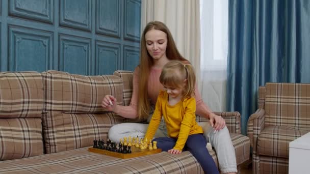 Liten söt dotter barn och ung mor spelar schack hemma soffa, fritidsintressen aktiviteter — Stockvideo