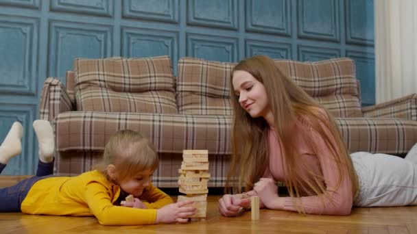 Mãe jogar blocos de madeira jogo de tabuleiro com filha pequena menina em casa, hobbies de lazer — Vídeo de Stock