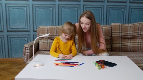 Bonito pequeno criança criança filha aprender desenho lição de casa com jovem mãe, casa distância educação — Vídeo de Stock