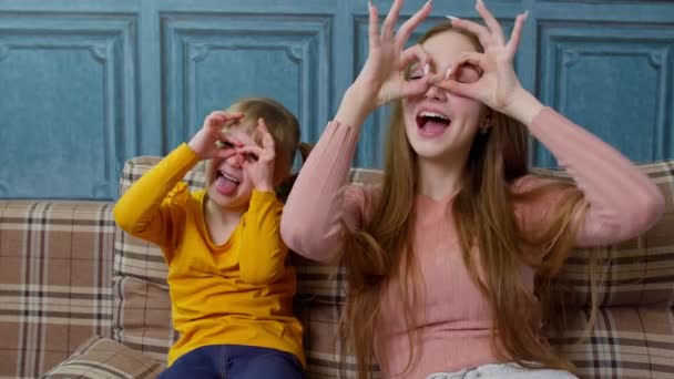 Lustige junge Mutter und Tochter machen lustige Gesichter beim Selfie zu Hause und genießen lustige Aktivitäten — Stockvideo