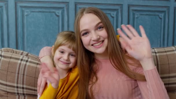 Child kid daughter with mother, embracing, waving hands to camera doing hello welcome or bye gesture — Stock Video