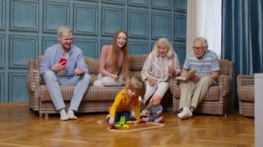 Mutlu çoklu aile tatilleri. Çift ebeveynler ve dedeler kanepede dinleniyor.