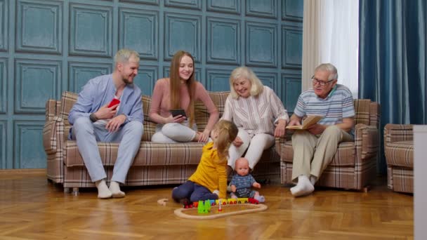 Szczęśliwy wielopokoleniowy rodzinny wypoczynek w domu para rodziców i wnuków relaks na kanapie — Wideo stockowe
