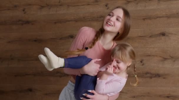 Jonge mooie moeder babysiter en kleine kind dochter springen dansen op bed in modern huis slaapkamer — Stockvideo