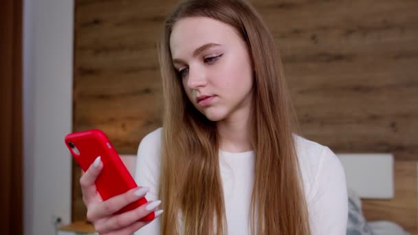 Girl looks at screen of smartphone makes successful online order, slowly browsing, surfing online — Stock Video