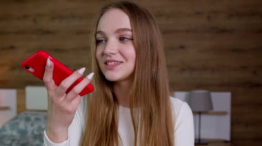 Gülümseyen genç kadın arkadaşlarına sesli mesaj kaydediyor, çevirmeni cep telefonunda kullanıyor