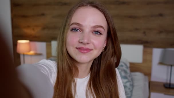 POVショットの若い笑顔女性ブロガー作る自撮り上のスマートフォン上のソーシャルメディアネットワークのためにホーム — ストック動画