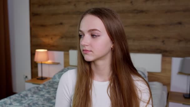 Smiling pretty young woman in good mood looking at camera, smiles gently on bedroom background — Stock Video