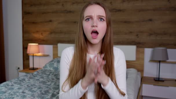 Upprörd ung kvinna i vit blus lyfter händerna i ilska och skriker wow, vidrör kinden, öppen mun — Stockvideo
