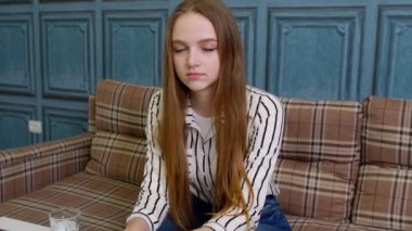 İş kadını evde bilgisayarla çalışıyor. Müşterilerle iletişim kuruyor. Tamam işareti gösteriyor.