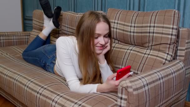 Fröhliches Mädchen liest gute Nachrichten, genießt erfolgreiche Einkäufe, feiert Lottogewinn auf dem Handy — Stockvideo