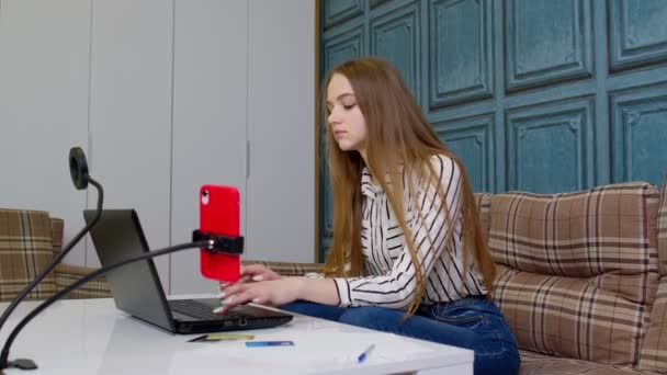 Souriant jeune femme d'affaires professionnel travaillant sur le téléphone à l'aide d'un ordinateur portable assis à la maison bureau — Video