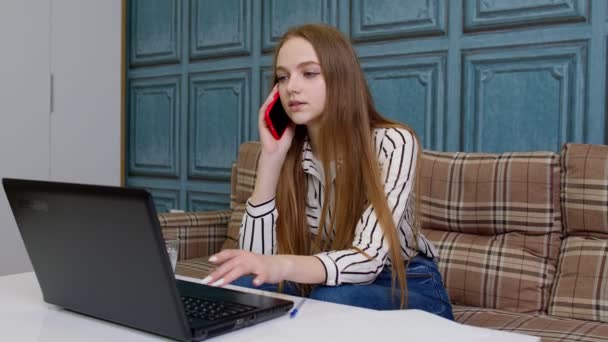 Joven mujer de negocios consultora profesional hablando, en el teléfono móvil, utilizando el ordenador portátil en la oficina en casa — Vídeos de Stock