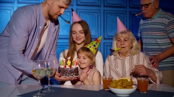 Lány ünnepli születésnapi party a szülőkkel, idősebb nagyszülők család elfújja gyertyák a tortán — Stock videók