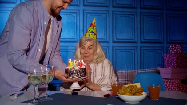 할머니 생일잔치를 벌이며 소원을 빌고 집에서 촛불을 불고 있는 대가족들 — 비디오