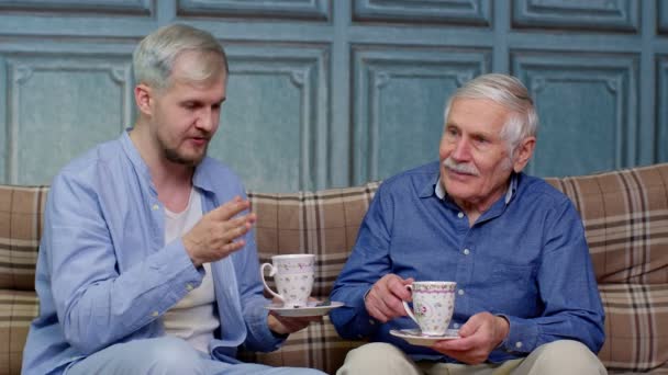 Diferentes gerações masculinas família de pai sênior e filho adulto ou neto relaxante, beber chá — Vídeo de Stock