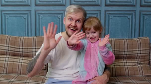 Padre e hija pequeña niño sonriendo, saludando alegremente, saludando hola, hola, bienvenidos juntos — Vídeos de Stock