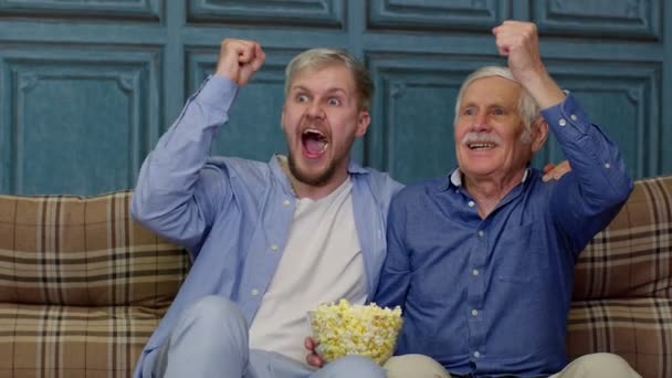 Abuelo mayor y los hombres jóvenes viendo el partido de fútbol en la televisión, los hombres generaciones familiares — Vídeos de Stock