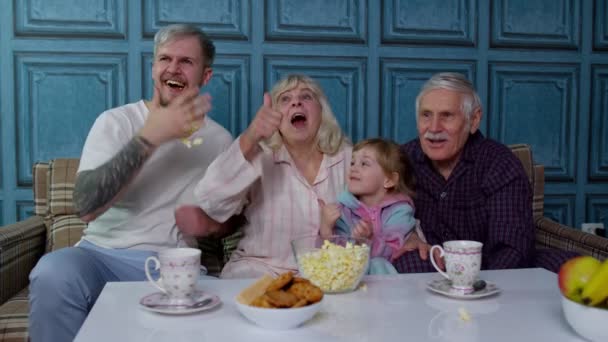 Família feliz multigeracional rindo, assistindo filmes de televisão de desenhos animados de comédia, comendo pipocas — Vídeo de Stock