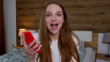 Kazanan teklifi kutlayan ya da cep telefonundan ekommerce indirimi alan kadın müşteri