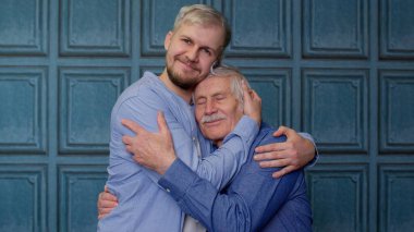Happy excited young man embracing gray-haired old dad or grandfather, male generations family clipart