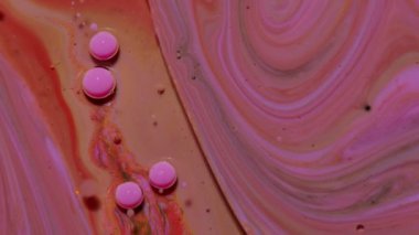 Pembe yağ damlalarının üst görünüm hareketi kabarcıklar, çok renkli sanatsal boya yüzeyi arka planı
