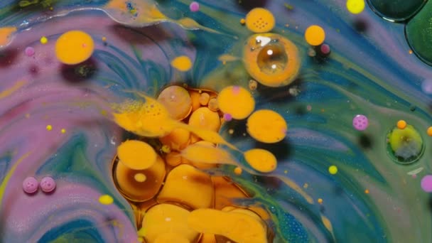 Burbujas de tinta mezcladas con sustancia líquida de aceite, leche, jabón, pintura acrílica brillante en la superficie colorida — Vídeo de stock
