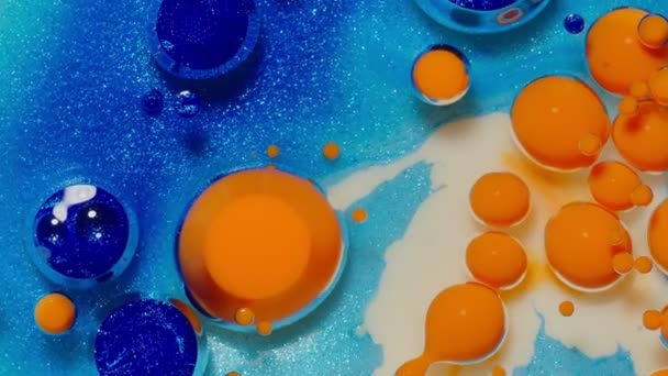 Burbujas de tinta mezcladas con sustancia líquida de aceite, leche, jabón, pintura acrílica brillante en la superficie colorida — Vídeo de stock