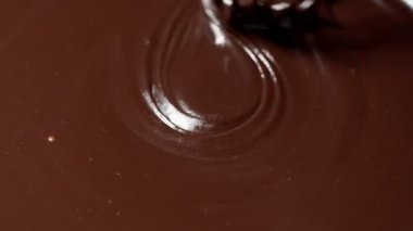 Karıştırma, karıştırma, eritilmiş siyah çikolatayla çırpma, şekerlemeci tatlı hazırlar.