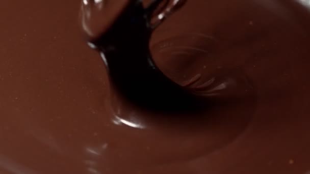 Slow motion mengen, roeren premium donkere gesmolten chocolade met een garde, proces van het maken van snoep — Stockvideo