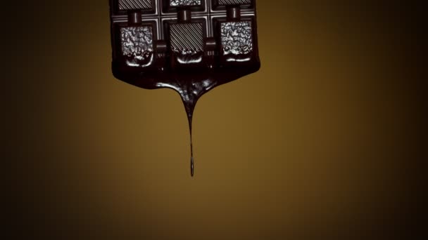 Trage beweging van chocoladereep met gesmolten pure chocolade druipend over bruine achtergrond — Stockvideo