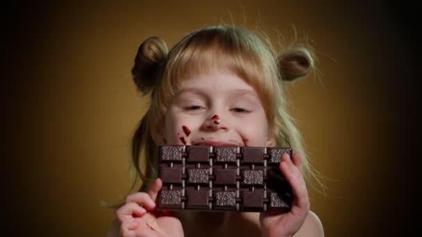 Nahaufnahme Porträt eines Teenie-Mädchens, das Milchschokolade isst, süchtig nach Süßigkeiten und Süßigkeiten — Stockvideo