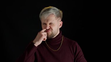 Komik, aptal bir stil adamı burun ve kulak karıştırıyor, sümük çıkarıyor, kültürsüz alışkanlıklar ediniyor, kötü davranışlar sergiliyor.