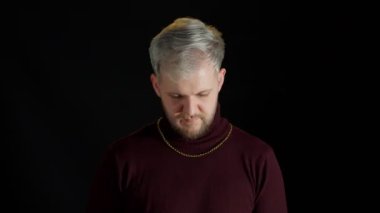 Moda kıyafetleri içinde gülümseyen neşeli genç adam el ele tutuşup kameraya bakıyor.