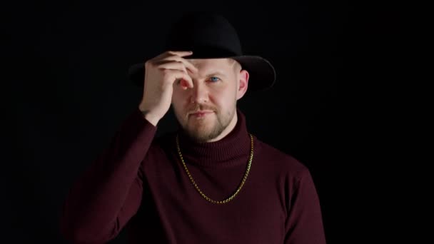 Portrait of seductive smile young man in trendy stylish clothes and hat against black background — Stok Video