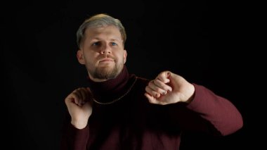 Yakışıklı disko dansçısı ritmik bir şekilde dans ediyor. Gece kulübünün siyah arka planında el ele tutuşuyor.