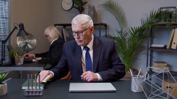 Reicher Senior Business Manager, der nach der Arbeit am tragbaren Laptop im Büro Geld in Dollar zählt — Stockvideo