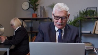 Dizüstü bilgisayara bakarken yeni bir proje geliştiriyor. Şaşırmış ve heyecanlı.