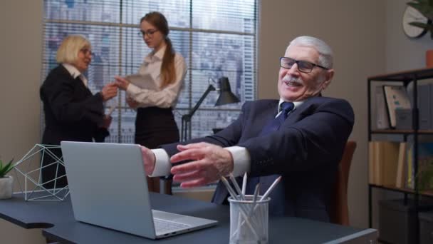 Fröhlich erwachsener alter Geschäftsmann hebt Hände und feiert plötzlichen Sieg mit Amtskollegen — Stockvideo