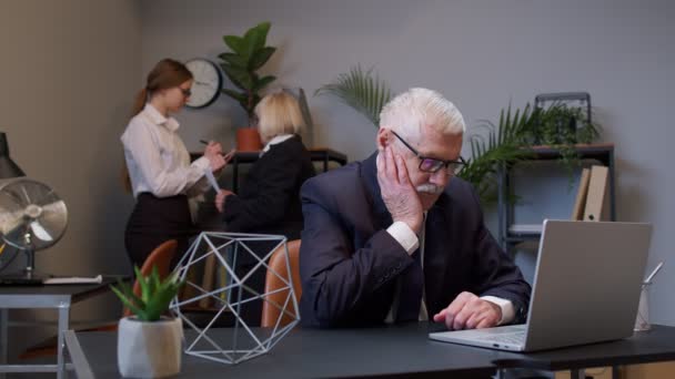 Nachdenklicher Geschäftsmann mit Laptop sitzt am Schreibtischarbeitsplatz und zeigt mit dem Finger auf das Eureka-Zeichen — Stockvideo