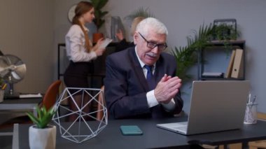 Kurnaz kıdemli işadamı ellerini ovuşturuyor, ofis içi planlar yapıyor.