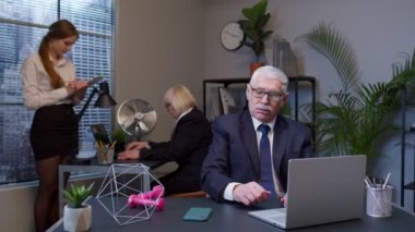 İş adamı sıkı çalıştıktan sonra ofis masasında otururken spor yapıyor.