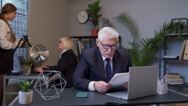 Несчастный пожилой человек босс делает большой палец вниз жеста выражая недовольство, неодобрение в офисе — стоковое видео
