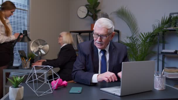 Uomo d'affari che fa esercizi di manubri fitness dopo un duro lavoro mentre si siede alla scrivania dell'ufficio sul posto di lavoro — Video Stock