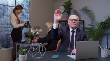 İş arkadaşlarıyla kıdemli iş adamları el sallayarak selamlaşır.