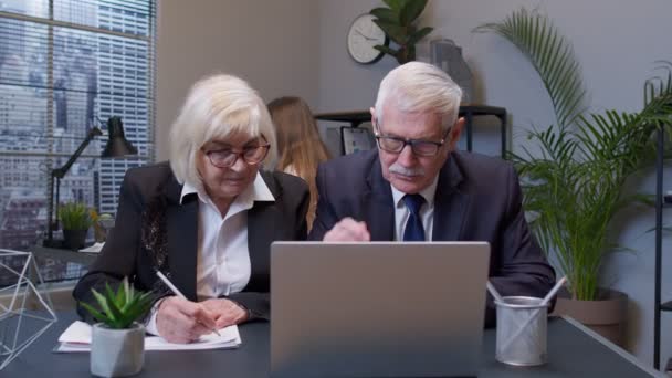 Senior patron homme avec collègue femme travaillant au bureau, secrétaire relaxant avec ventilateur électrique — Video