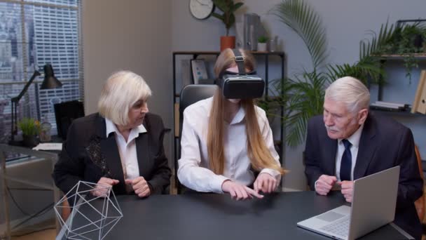 Mujer con gafas de realidad virtual intenta aplicación 3D para casco VR mientras sus colegas la apoyan — Vídeos de Stock