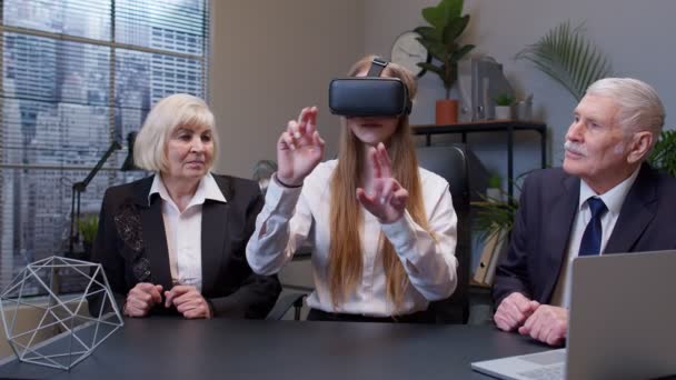 Mulher vestindo óculos de realidade virtual tenta aplicativo 3D para capacete VR, enquanto os colegas apoiá-la — Vídeo de Stock